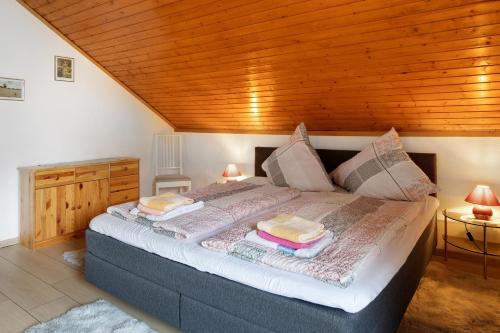 a bedroom with a bed with a wooden ceiling at Apartmenthaus Fister in Schluchsee