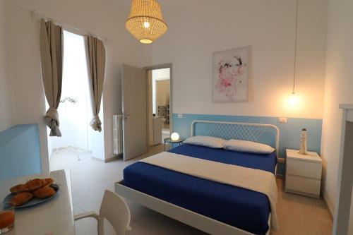 a bedroom with a blue bed and a table at Casa vacanze Aura a Otranto in Otranto