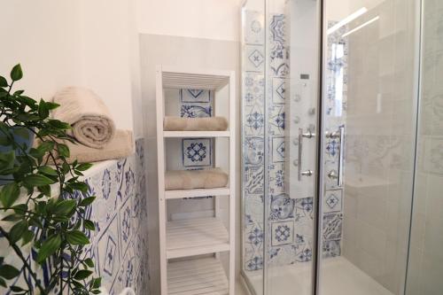 a bathroom with a shower with blue and white tiles at Casa vacanze Aura a Otranto in Otranto