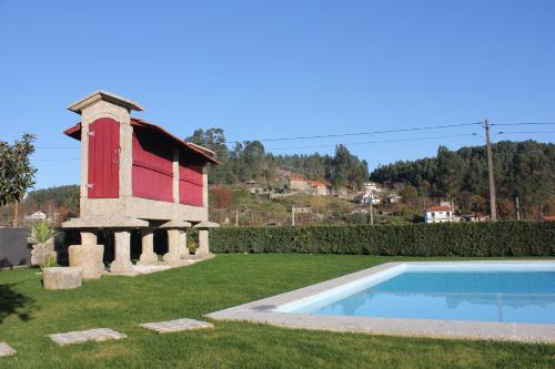 a house with a red door and a swimming pool at Casa do Sobreira in Vieira do Minho