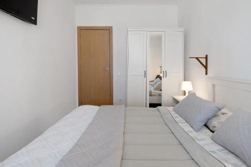 a white bedroom with a large white bed in it at Nuria House in Praia da Vitória