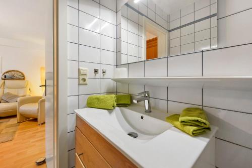 a bathroom with a sink with green towels on it at Thum in Daisendorf