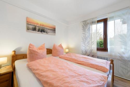 a bedroom with a bed with pink sheets and a window at Thum in Daisendorf