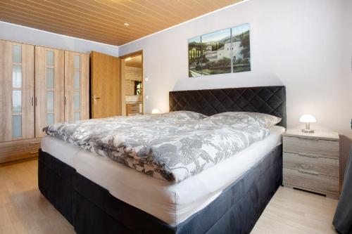 a bedroom with a large bed with a wooden headboard at Ferienwohnung K Schröder in Sundhagen-Niederhof