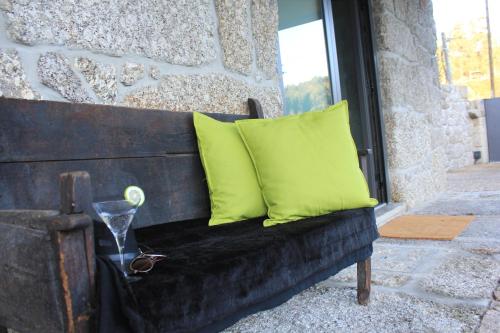 a bench with two green pillows and a window at Casa do Sobreira in Vieira do Minho