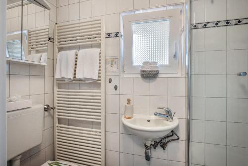 a white bathroom with a sink and a shower at Ferienwohnung Dahmlos in Kremperheide