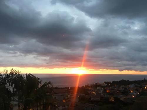 a sunset with a rainbow in the sky over the ocean at Best Western Hotel Santa Caterina in Acireale