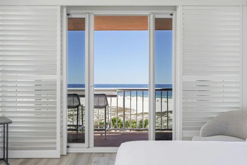 a bedroom with a view of the ocean through sliding glass doors at Perdido Beach Resort in Orange Beach