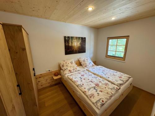 a small bedroom with a bed and a window at Ferienwohnung am Nettenbach in Bernau im Schwarzwald