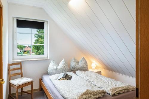 a bedroom with a bed and a window at Ferienwohnung An der Haferkoppel in Groß Kussewitz