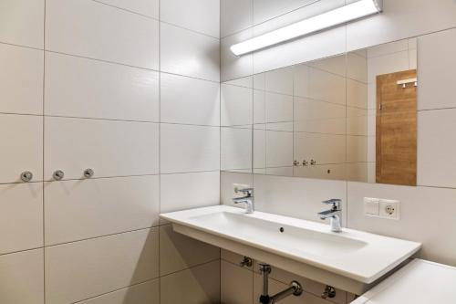 a white bathroom with a sink and a mirror at Ferienwohnung Brandbergblick in Mayrhofen