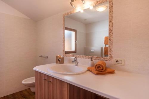 a bathroom with a sink and a mirror at Schildberghof Panorama in Kastelruth