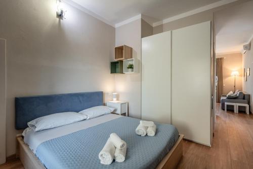 a bedroom with a blue bed with towels on it at La casina di Kino in Lucca