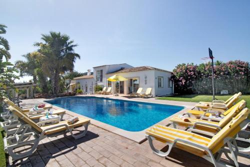 a swimming pool with lounge chairs and a house at Country House Quinta da Ilda in Loulé