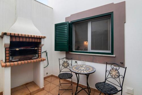 a balcony with a table and chairs and a window at Estrela do mar in Santa Luzia