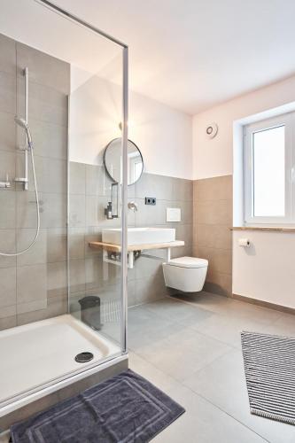 a bathroom with a shower and a sink and a toilet at Alte Seifensiederei - Fabienne in Bad Tölz