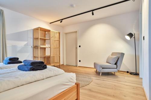 a bedroom with a bed and a chair at Alte Seifensiederei - Fabienne in Bad Tölz