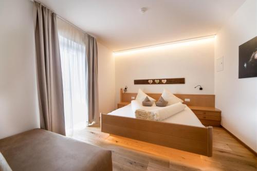 a bedroom with a bed and a large mirror at Sonnleiten Sonnenparadies in Collepietra