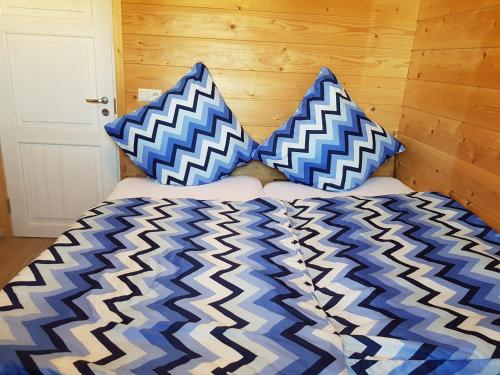 a bed with blue and white pillows on it at Ferienhaus Wolfshütte in Hillesheim