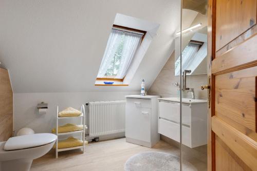 a bathroom with a toilet and a sink and a window at Haus Hachmann Wesselburen in Wesselburen