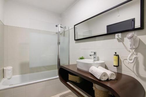 a bathroom with a sink and a bath tub at Altura Beach Villa in Altura