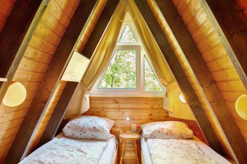 two beds in a small room with a window at Villa Königsdorf am See in Waldkirchen