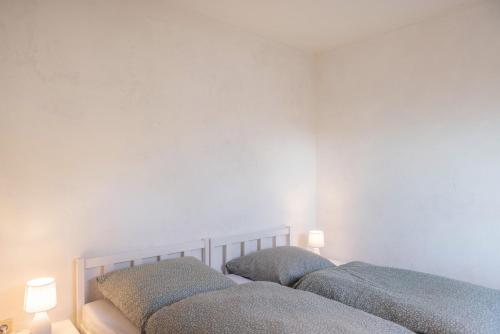 two beds in a bedroom with two lamps on the wall at Pension Stilletal - Springstille in Springstille