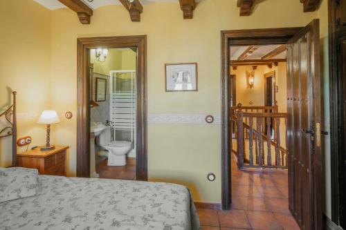 a bedroom with a bed and a bathroom with a toilet at Villa De Urueña Casa de Ilustres in Urueña