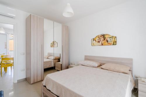 a white bedroom with a bed and a table at Donasand_torre san giovanni in Torre San Giovanni Ugento