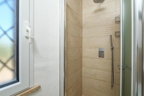a shower with a glass door in a bathroom at Confortevole villetta caposchiera in San Teodoro