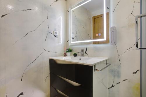 a bathroom with a sink and a mirror at Moradia Dos Castelos Azul in Ourém