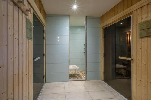 a hallway with glass doors and a walk in shower at Appartement B56 - Eco Le Ruitor in Sainte-Foy-Tarentaise