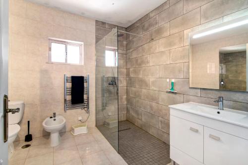a bathroom with a toilet and a sink and a shower at Casa Arcadia T3 in São Bartolomeu de Messines