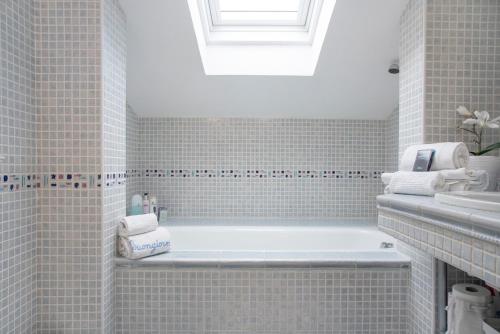 a white bathroom with a tub and a sink at Mansarda Massimo - Verbania Intra in Verbania