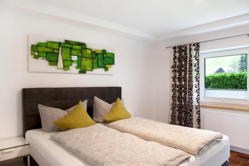 a bedroom with a bed with yellow pillows and a window at Apart Löffler in Kappl