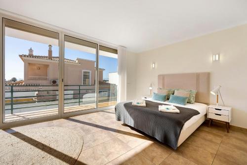 a bedroom with a large bed and a large window at Lagos Beach Pool Villa in Lagos