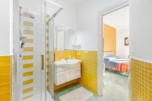 a bathroom with a sink and a shower and a bed at Coast 2 Coast in Agerola