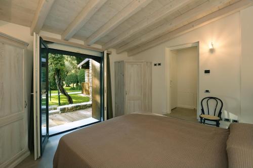 a bedroom with a bed and a sliding glass door at Al segnavento Tramontana in Toscolano Maderno