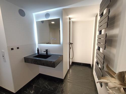 a bathroom with a black sink and a mirror at Ferienhaus zum Frankenblick in Sonneberg