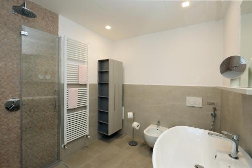 a bathroom with a tub and a shower and a sink at Al segnavento Tramontana in Toscolano Maderno