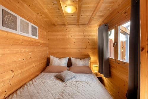 a bed in the corner of a wooden cabin at Haus Seebrise - Marina Mücheln in Mücheln