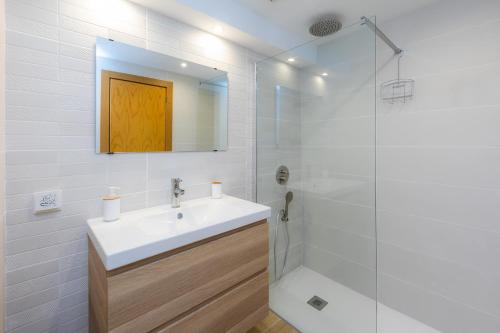 a white bathroom with a sink and a shower at Can Nogueras in Cala Ratjada
