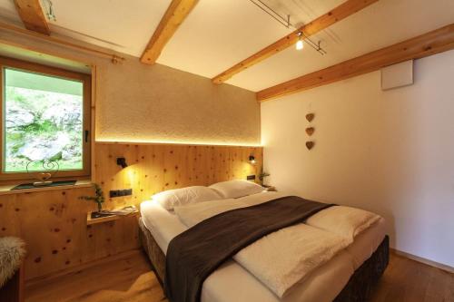 a bedroom with a large bed in a room with a window at Mühlanderhof Apt Klopairspitze in Resia