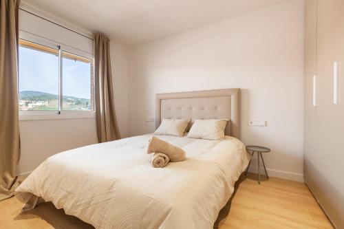 a bedroom with a large white bed with a window at Blue Coast Apartment in Canet de Mar