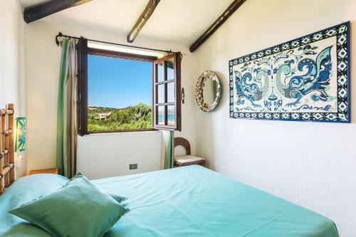 a bedroom with a bed and a window at Casa Mucchi Bianchi PC33 in Arzachena