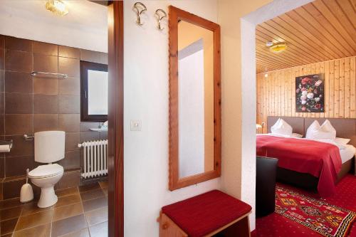 a hotel room with a bed and a bathroom at Hotel Bären - drei Sterne in Bernau im Schwarzwald