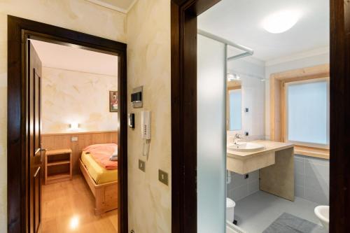a bathroom with a sink and a bedroom at I Mini Appartamenti in Livigno