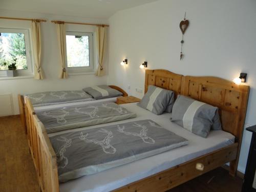 two twin beds in a bedroom with two windows at Ferienhaus Lemberger in Jochberg