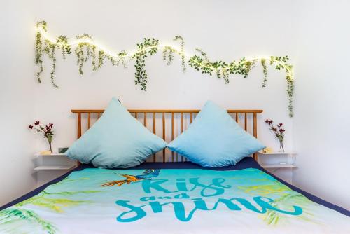 a bed with blue pillows and a sign that says kiss and sing at Schwabenseenestle in Uhldingen-Mühlhofen