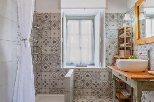 a bathroom with a sink and a window and a tub at Martha's House in Spetses